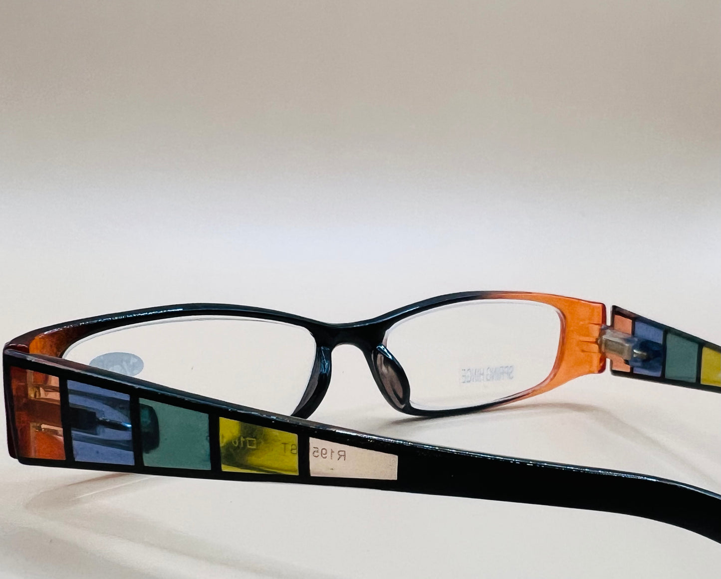 GEOMETRIC NARROW READERS.  BLACK FRAME FRONT WITH MULTI-COLOR ARMS